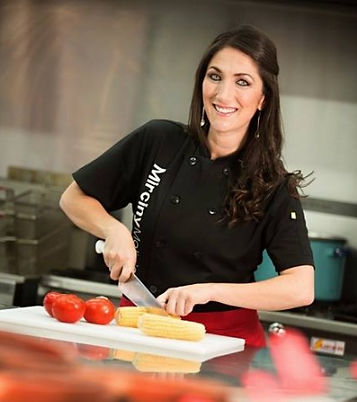 Photo of Mirciny Moliviatis in her black chef's uniform cooking
