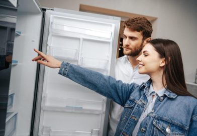 una pareja inspeccionando refrigeradoras para comprarlas.